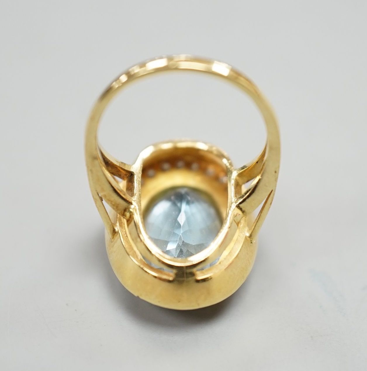 A modern 18ct gold, blue topaz and diamond set oval cluster ring, size L/M, gross weight 8.3 grams.